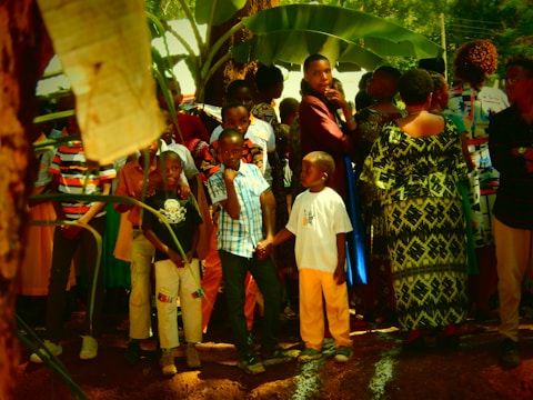 Elders and youth sharing stories under the shade of large Amazonian trees.