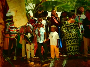 An outdoor scene showing descendants sharing stories and laughter under the shade of large trees