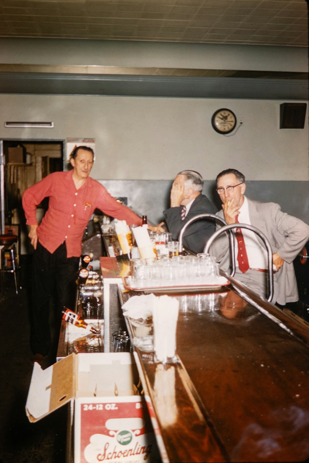 a group of men standing around a bar