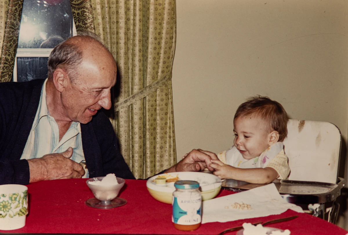 Thomas Ellsworth feeding his daughter Margaret at the kitchen table, 1979