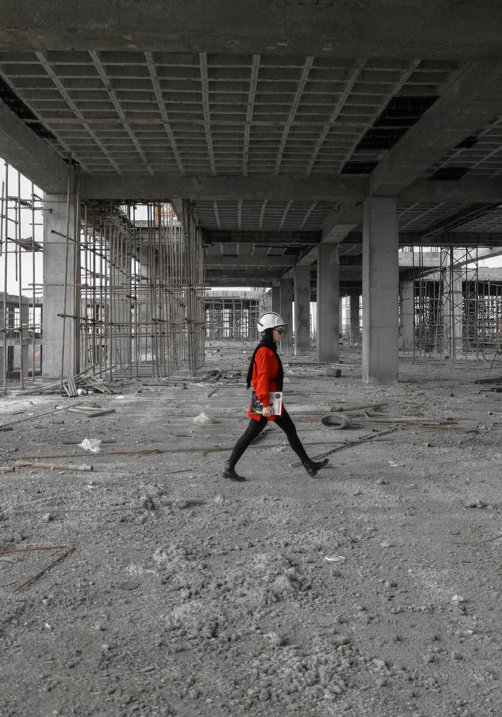 赤いジャケットを着た男が建設現場を歩いている