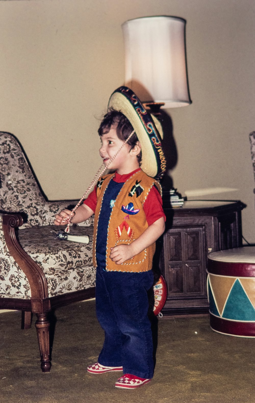 a young boy wearing a sombrero standing in a living room