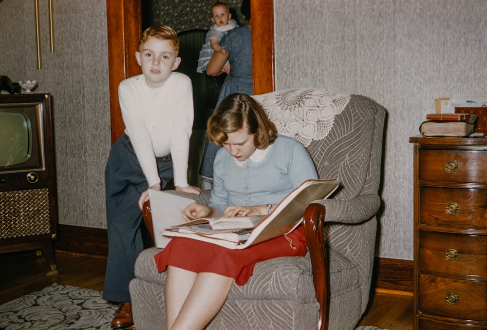 a woman sitting in a chair next to a young boy