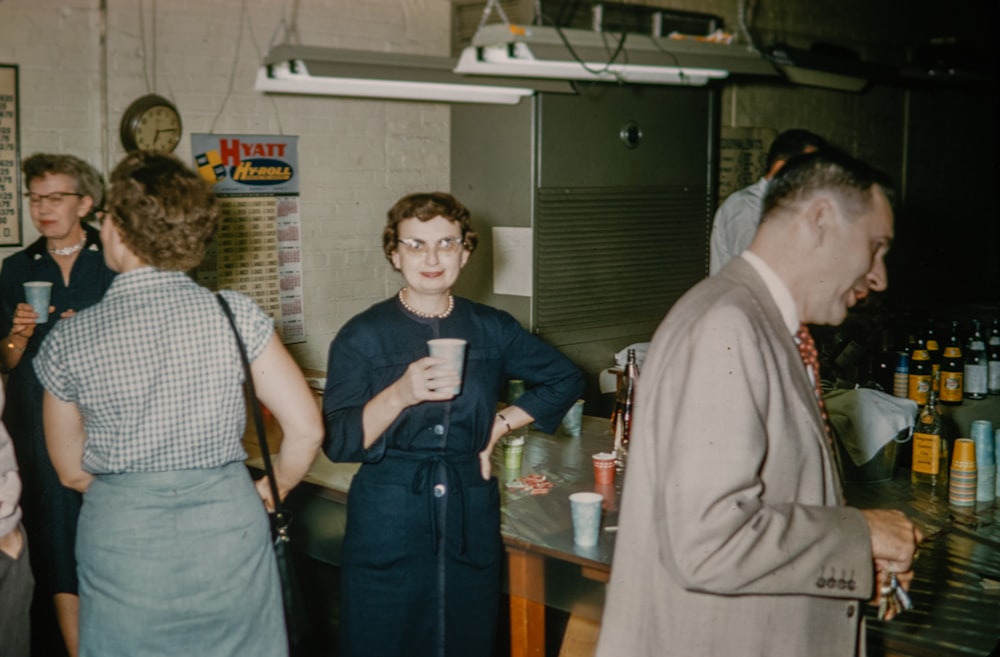 a group of people standing around a bar