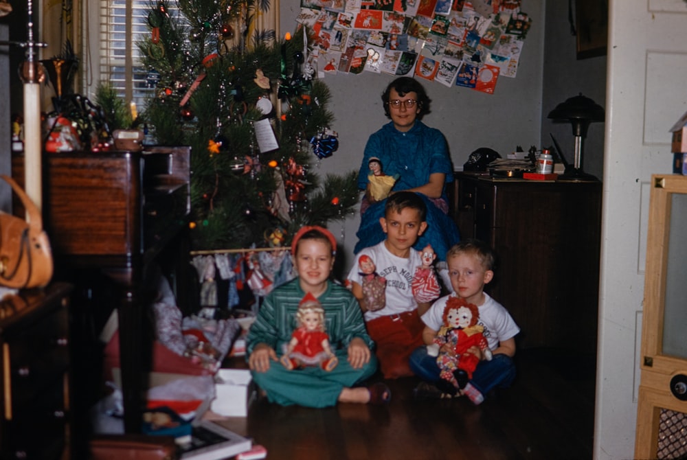 a group of people sitting around a christmas tree