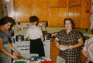 Group of women cooking together in a rustic kitchen.