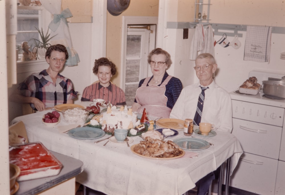 a group of people sitting around a table with food on it