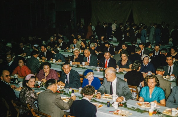 A group of diverse people sharing a meal at a social aid gathering