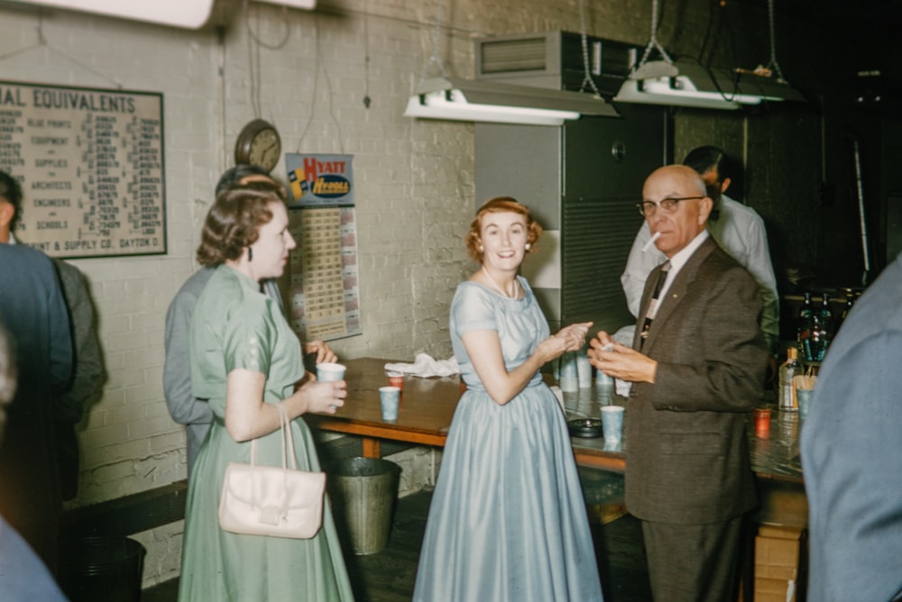 a group of people standing around a wooden table