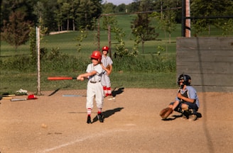 a young boy swinging a baseball bat at a ball