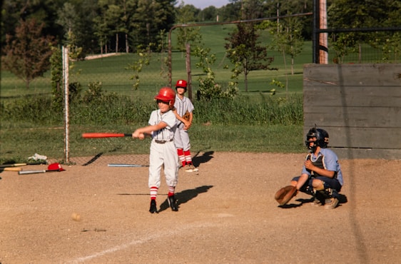 a young boy swinging a baseball bat at a ball