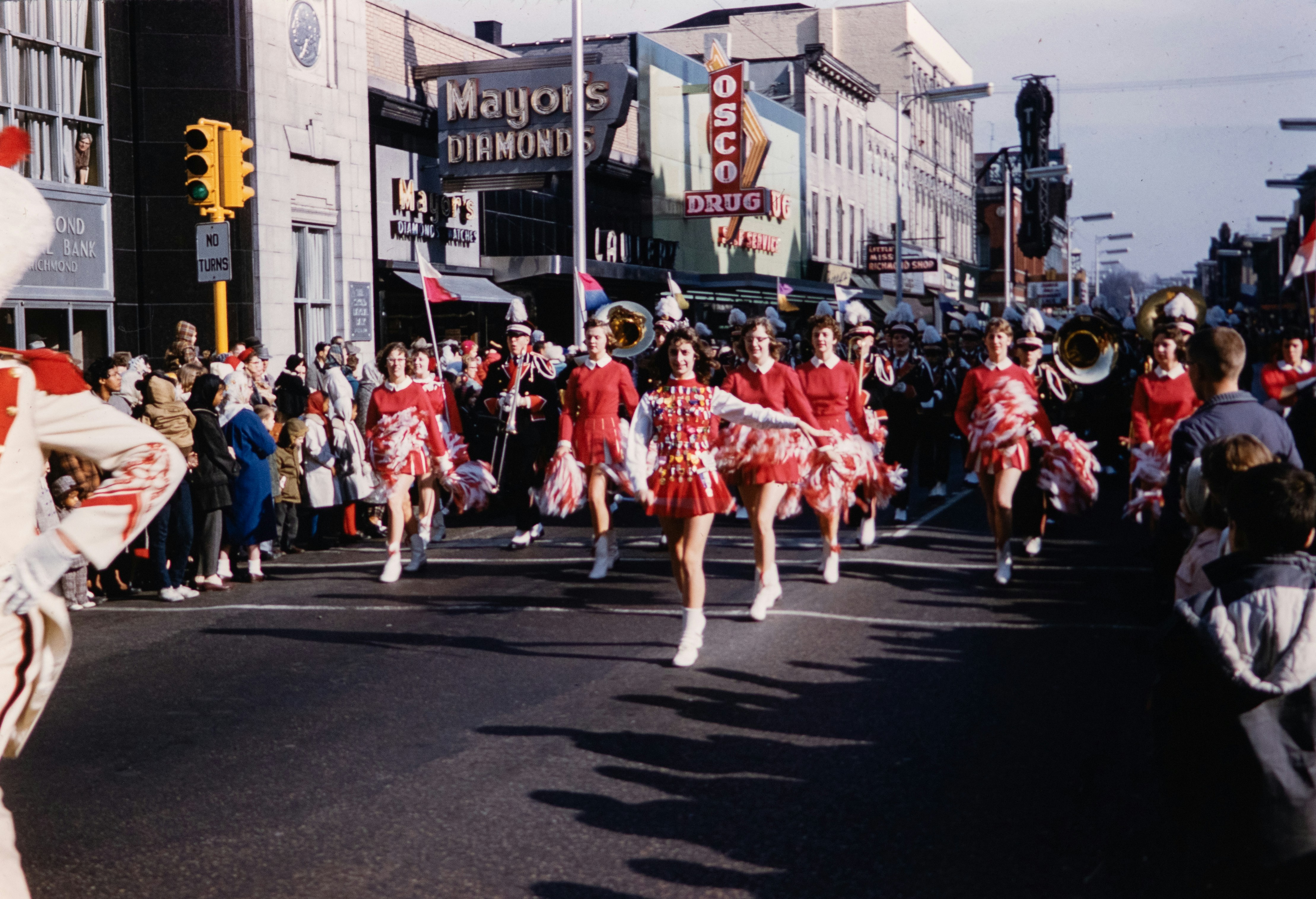 a group of cheerleaders marching down a street, 