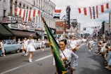 Vintage parade down Main Street with townsfolk waving flags.