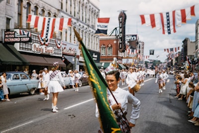 Vintage parade down Main Street with townsfolk waving flags.
