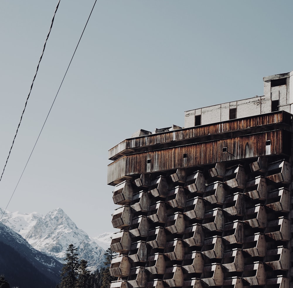a building made of concrete blocks with mountains in the background