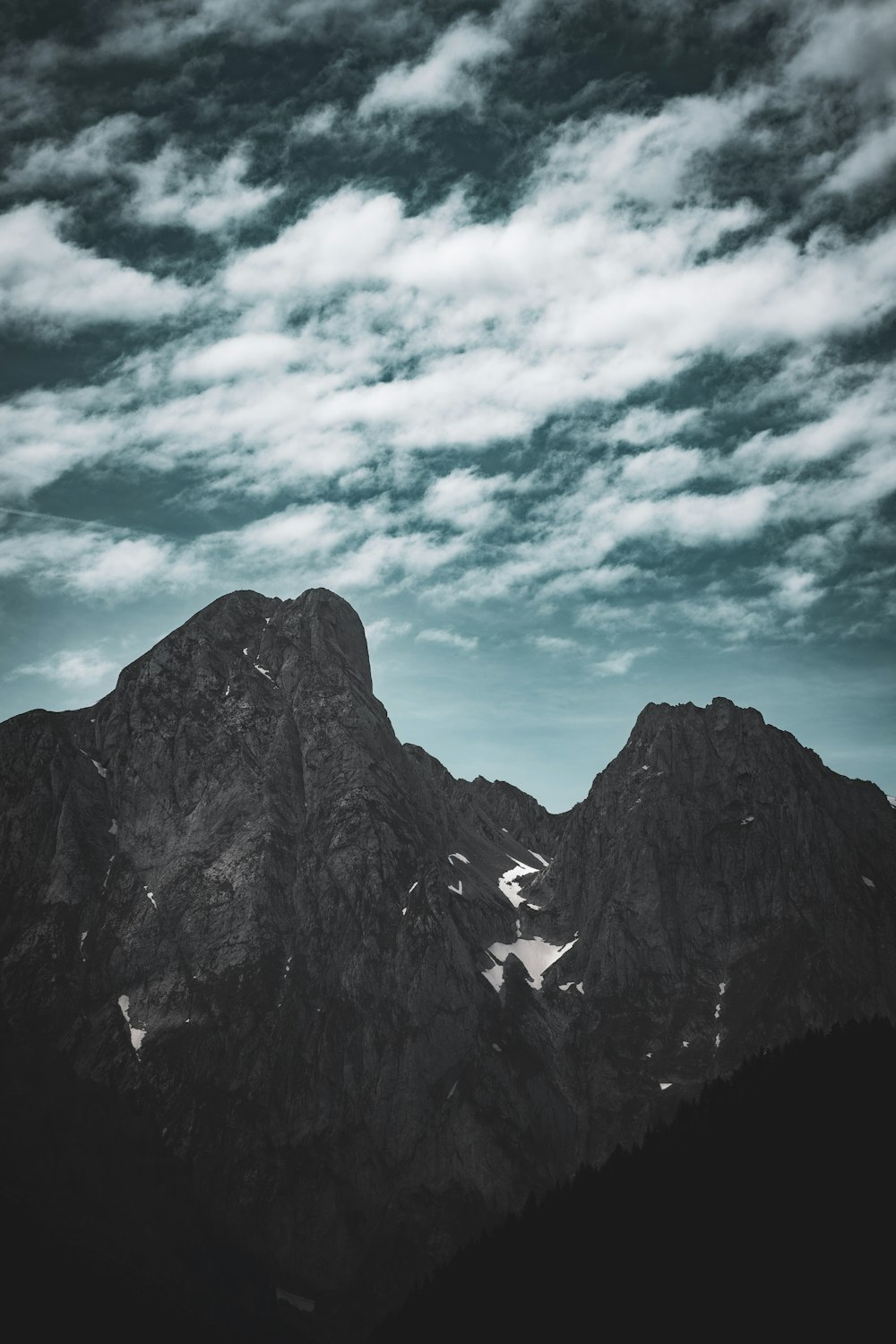 a black and white photo of mountains under a cloudy sky