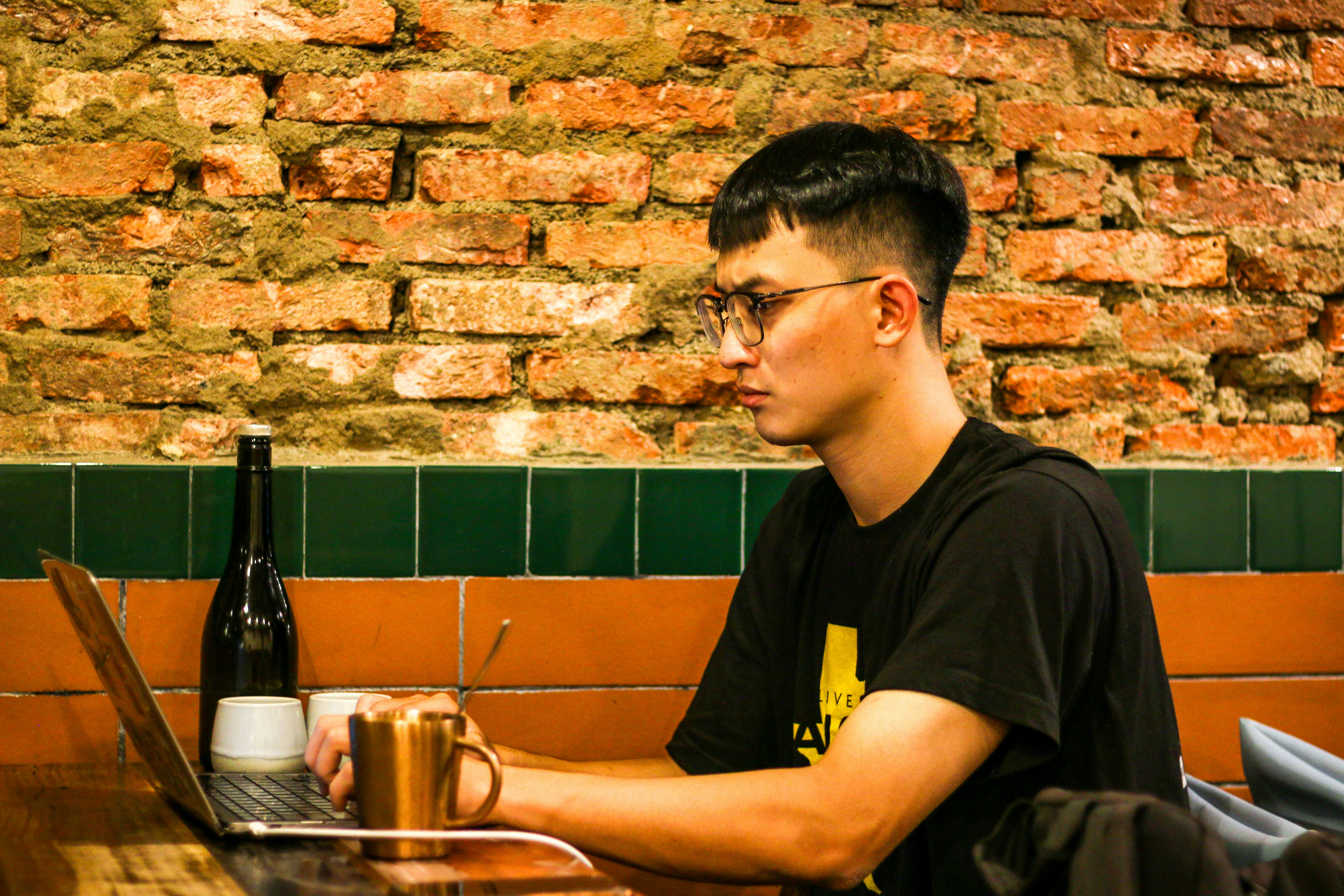 Seorang pria duduk di depan komputer laptop