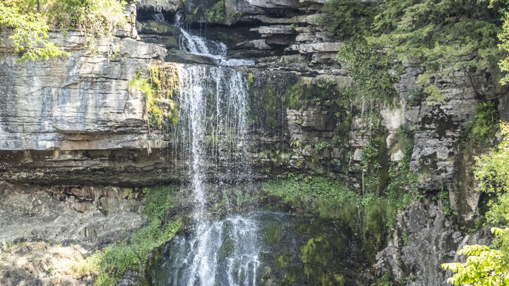 a waterfall with a large waterfall cascading down it's side