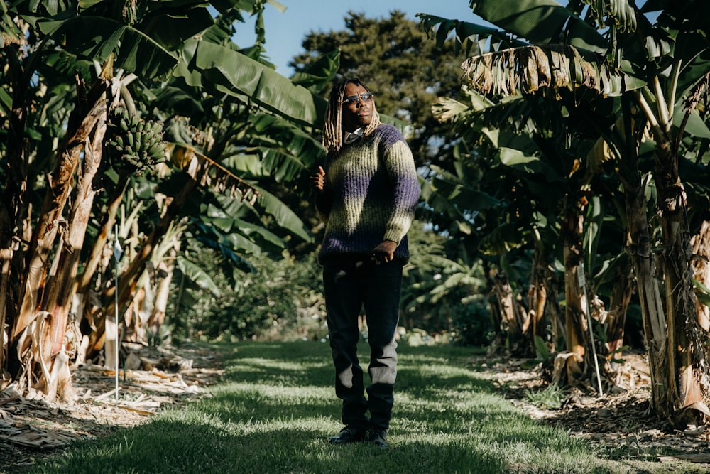 a man standing in the middle of a banana plantation