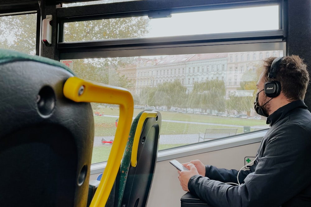 a man wearing headphones sitting on a bus
