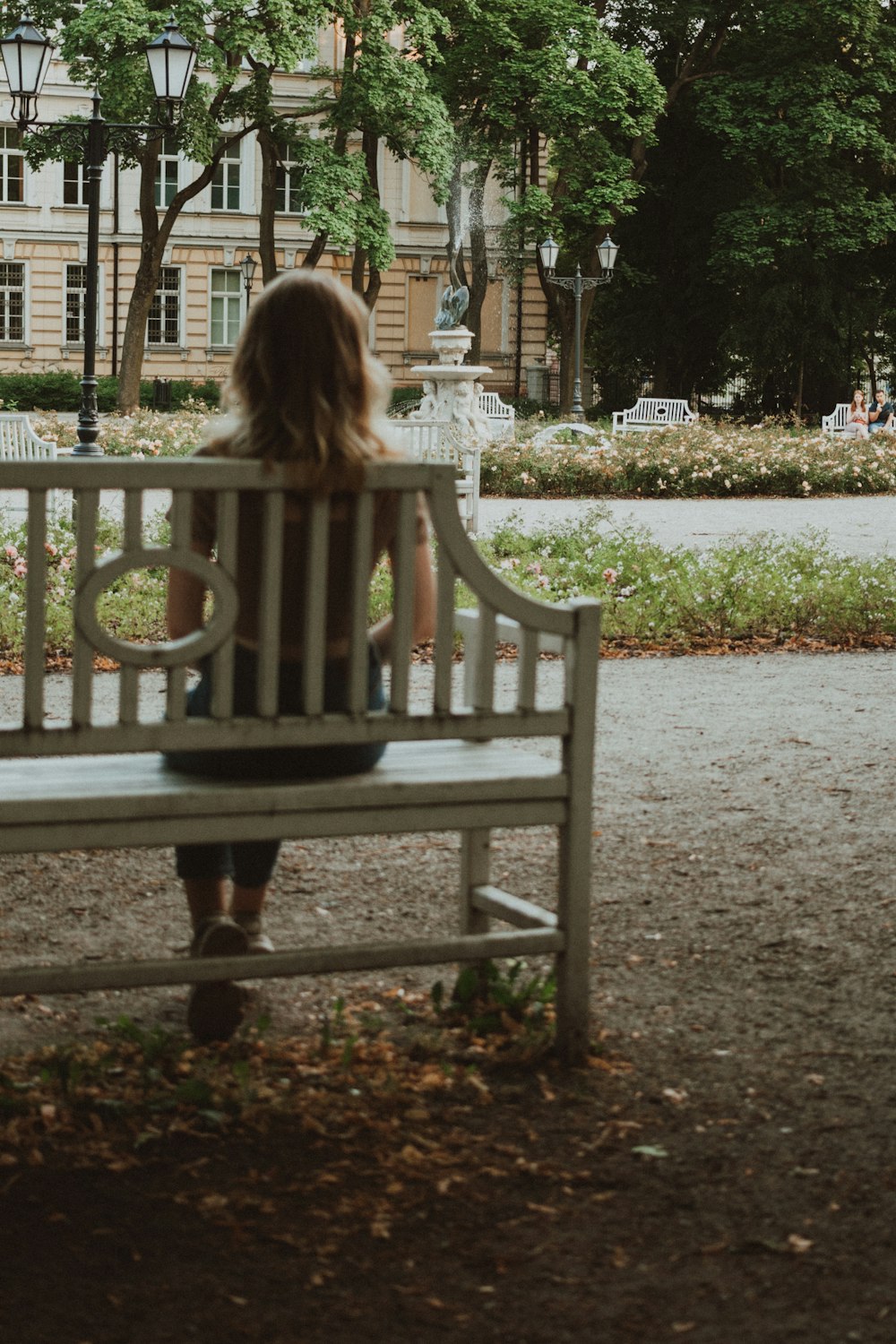 a woman sitting on a bench in a park