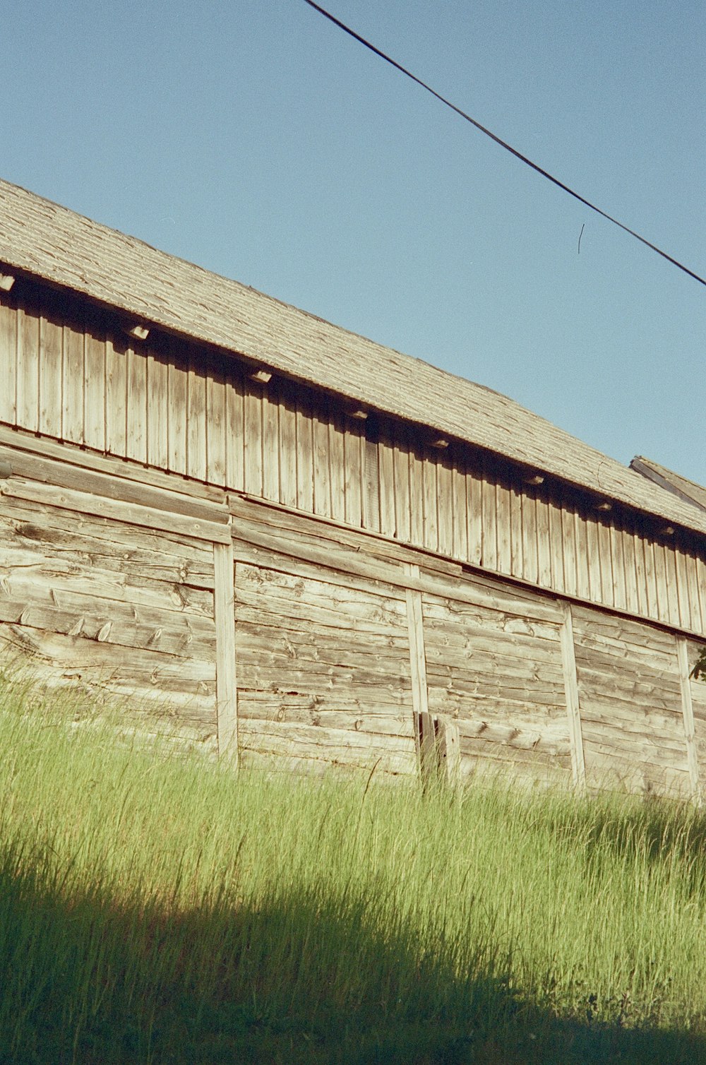 a wooden barn with a power line above it
