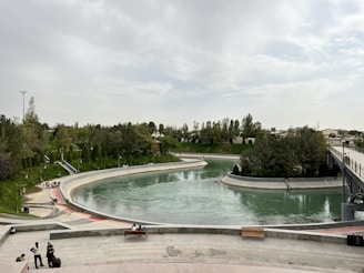 Artificial lake surrounded by greenery with visible water treatment devices.