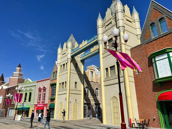 A lively street scene in Pune showcasing traditional Maharashtrian attire and architecture under a clear blue sky.