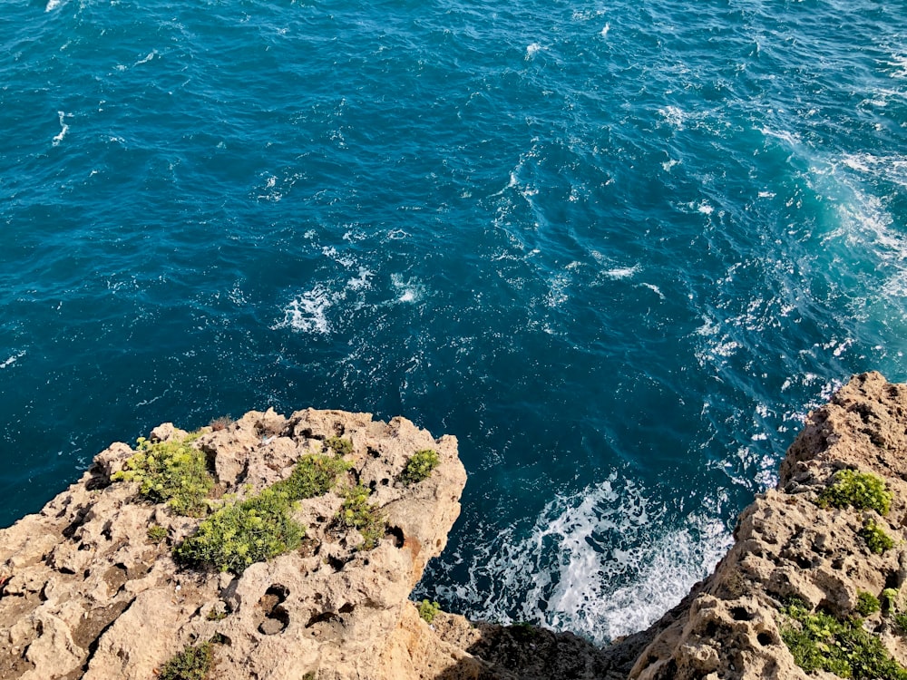 Blick auf ein Gewässer von einer Klippe