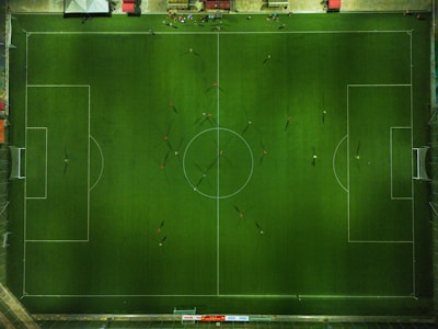 An overhead shot of a perfectly lined football pitch with players warming up.