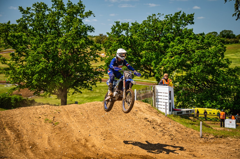 a man riding a dirt bike on top of a dirt hill