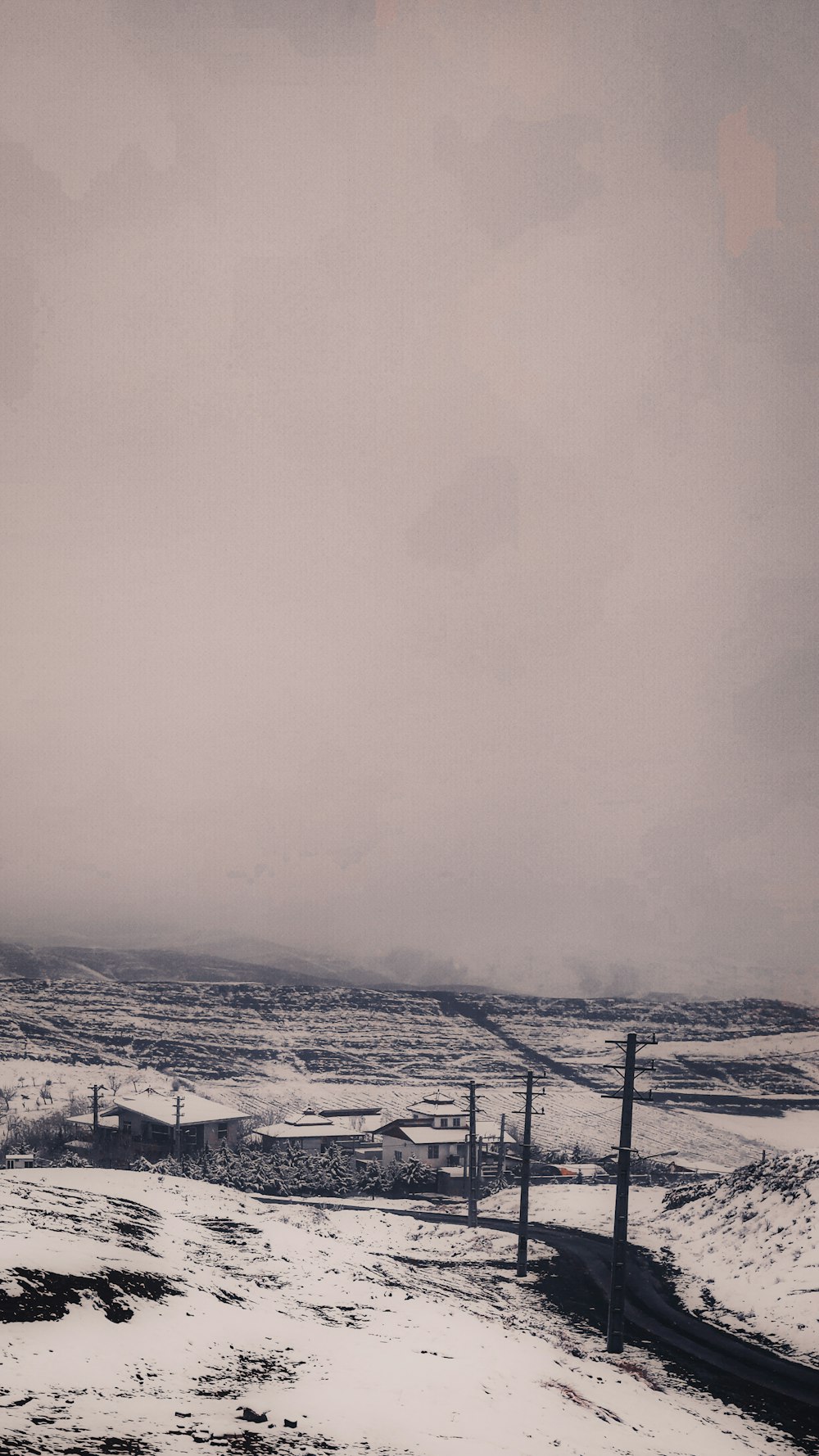 a snow covered field with a fence and snow covered ground