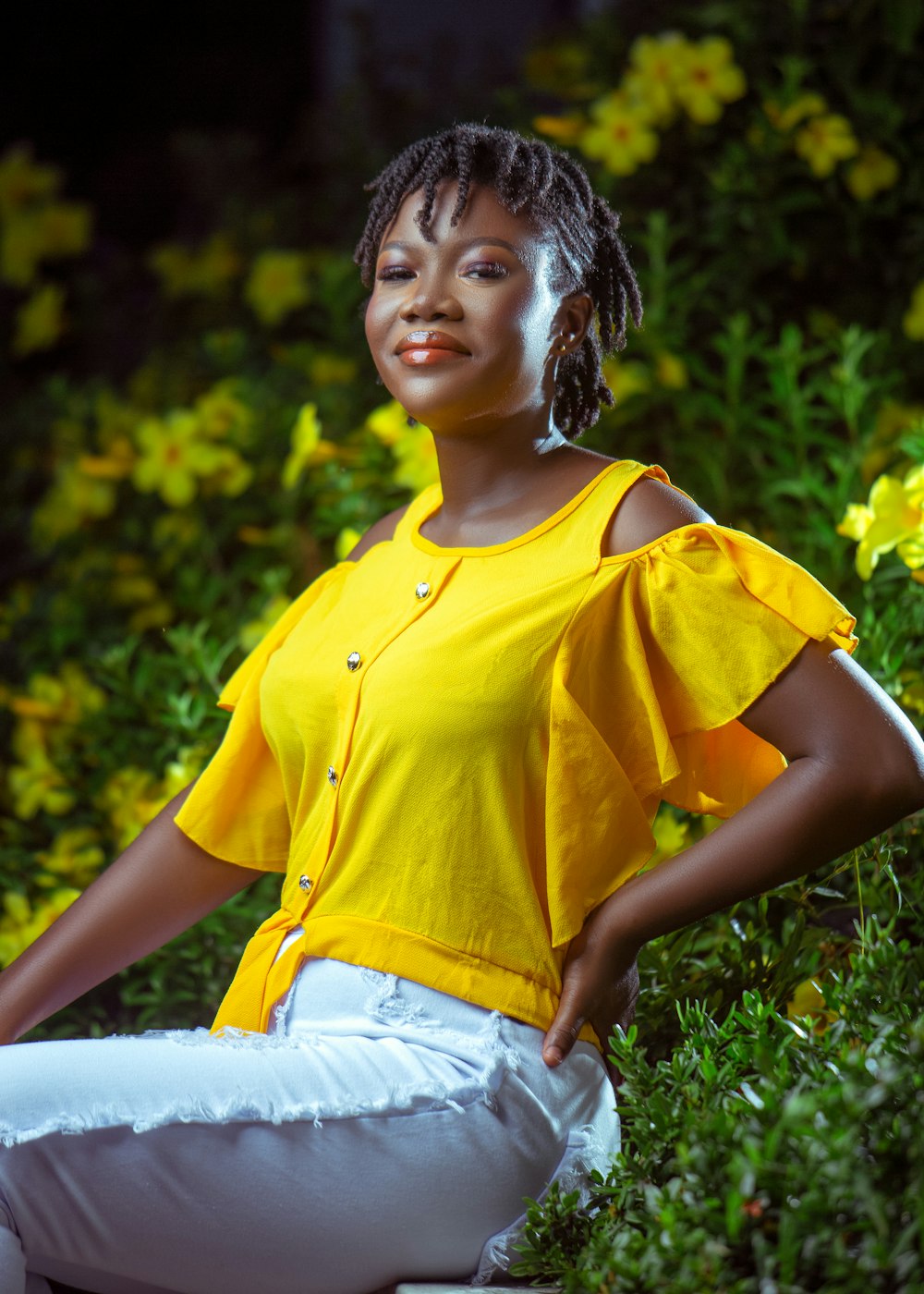 Une femme en chemise jaune et pantalon blanc