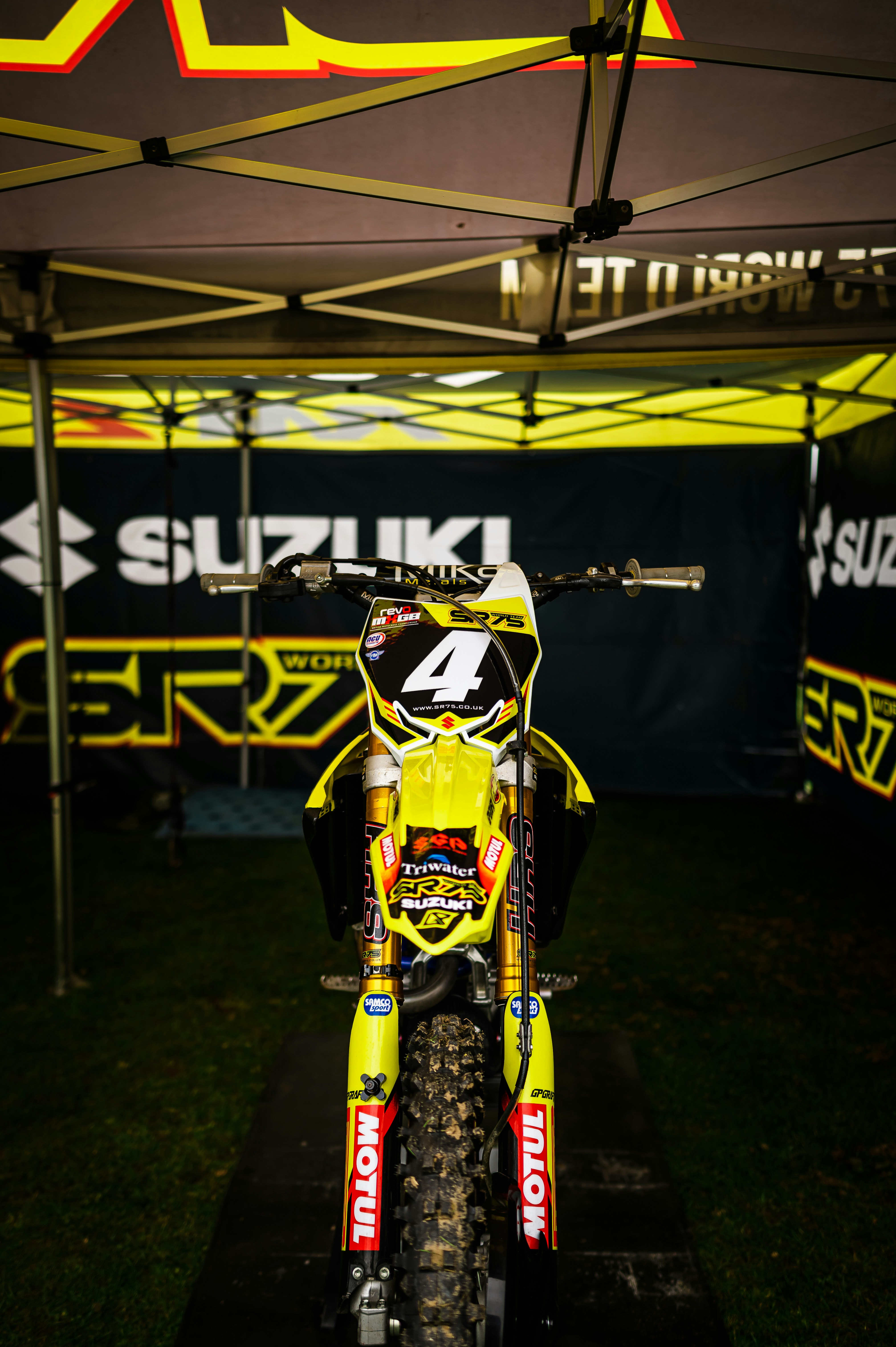 a yellow dirt bike parked under a tent