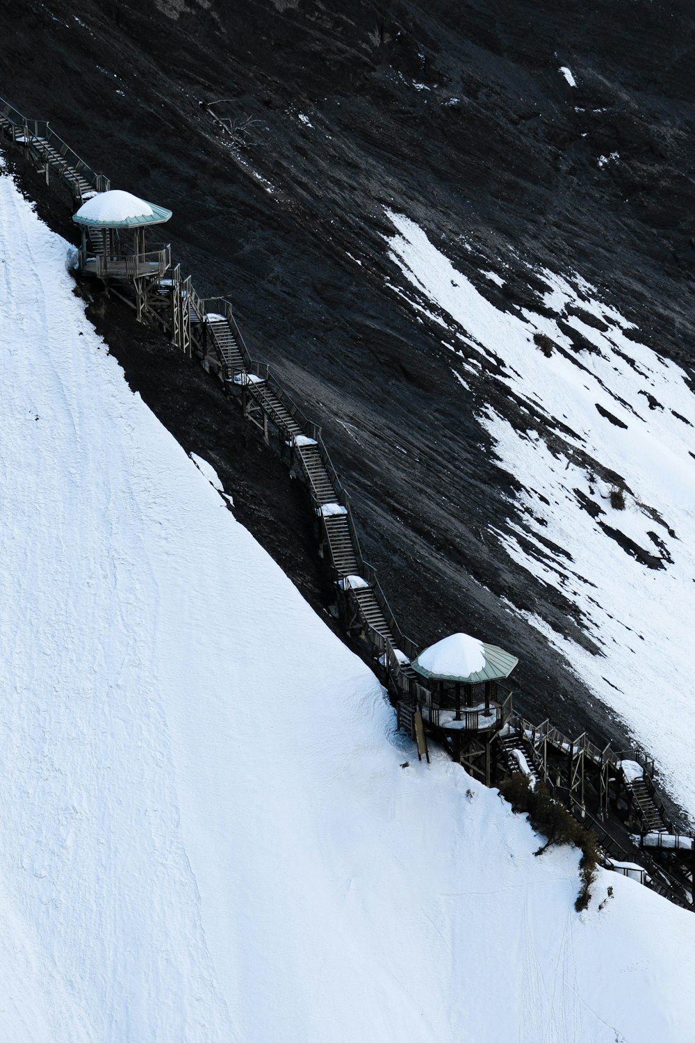 a snow covered hill with a small structure on top of it