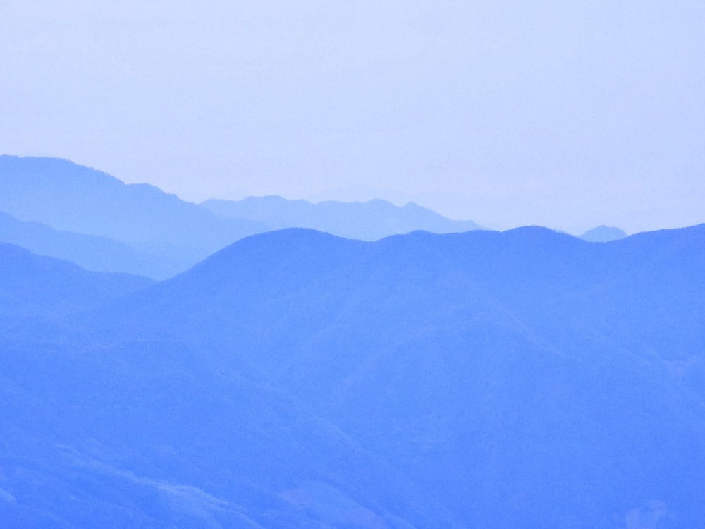 a plane flying over a mountain range in the sky