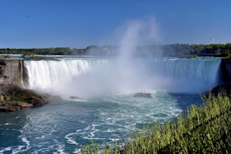 a boat is in the water near a waterfall