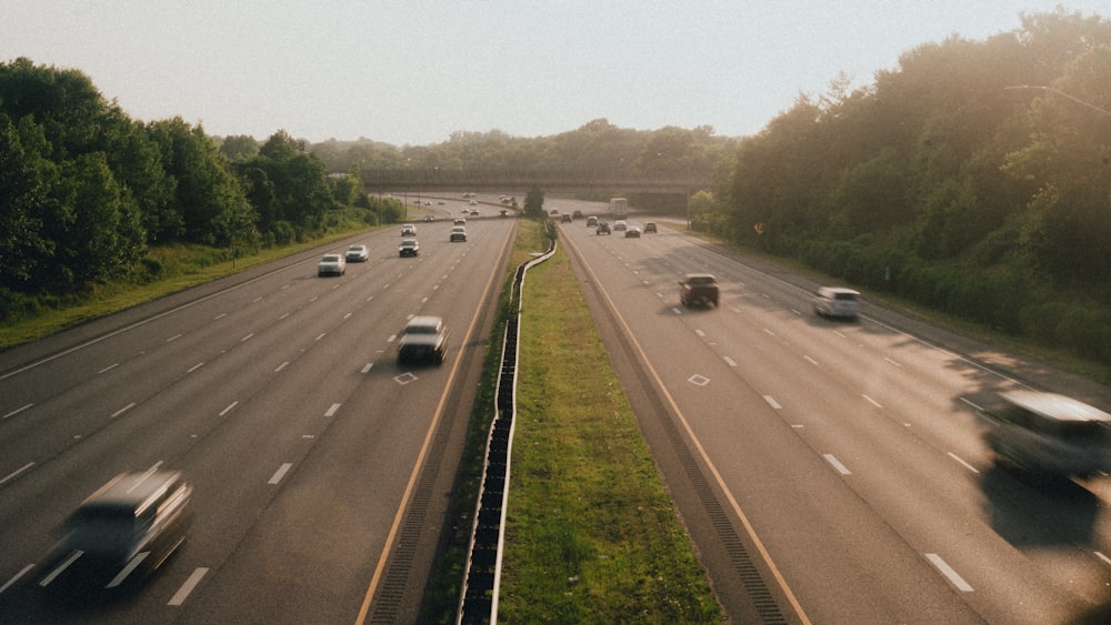 a highway filled with lots of traffic next to a forest