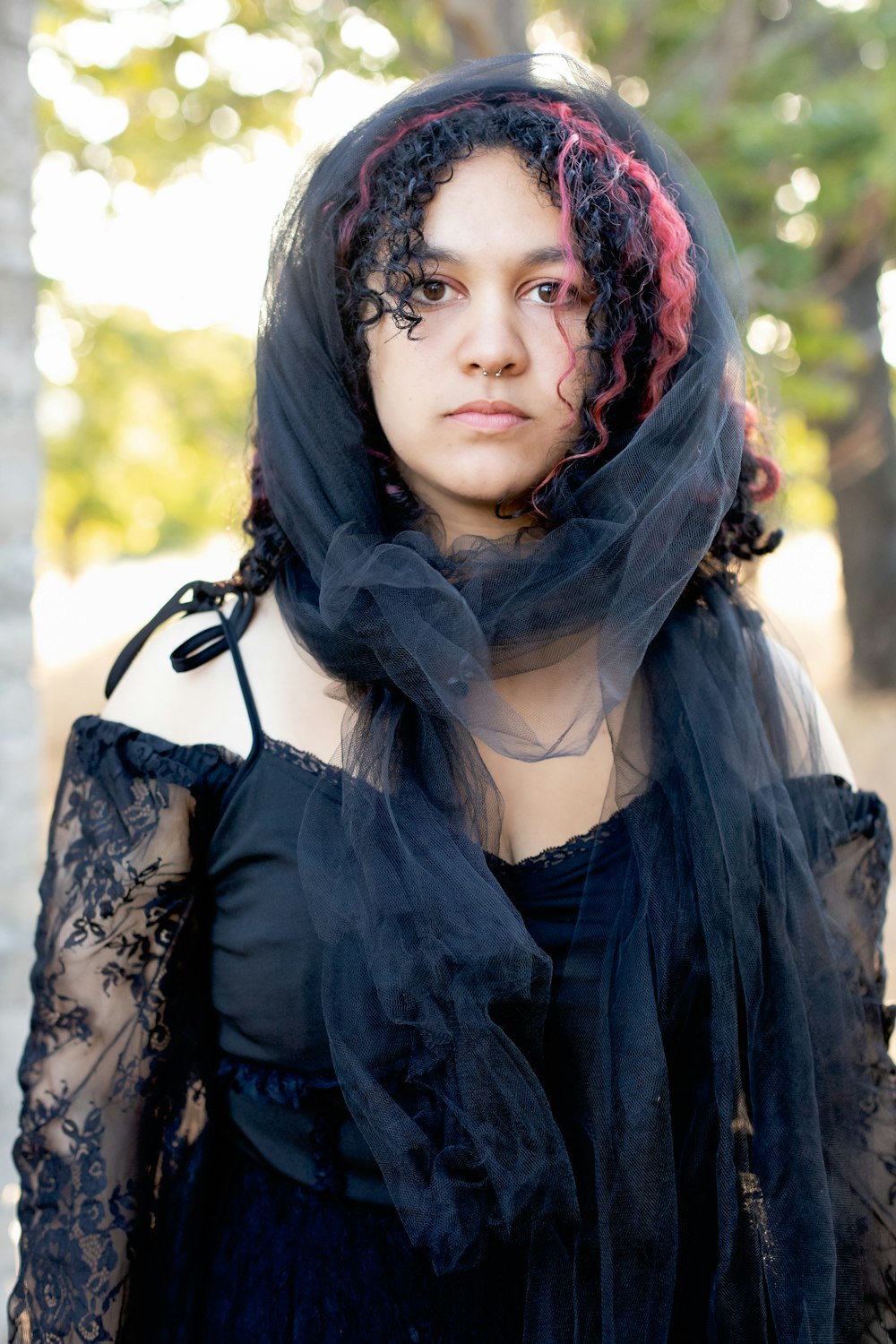 a woman wearing a black veil and a black dress