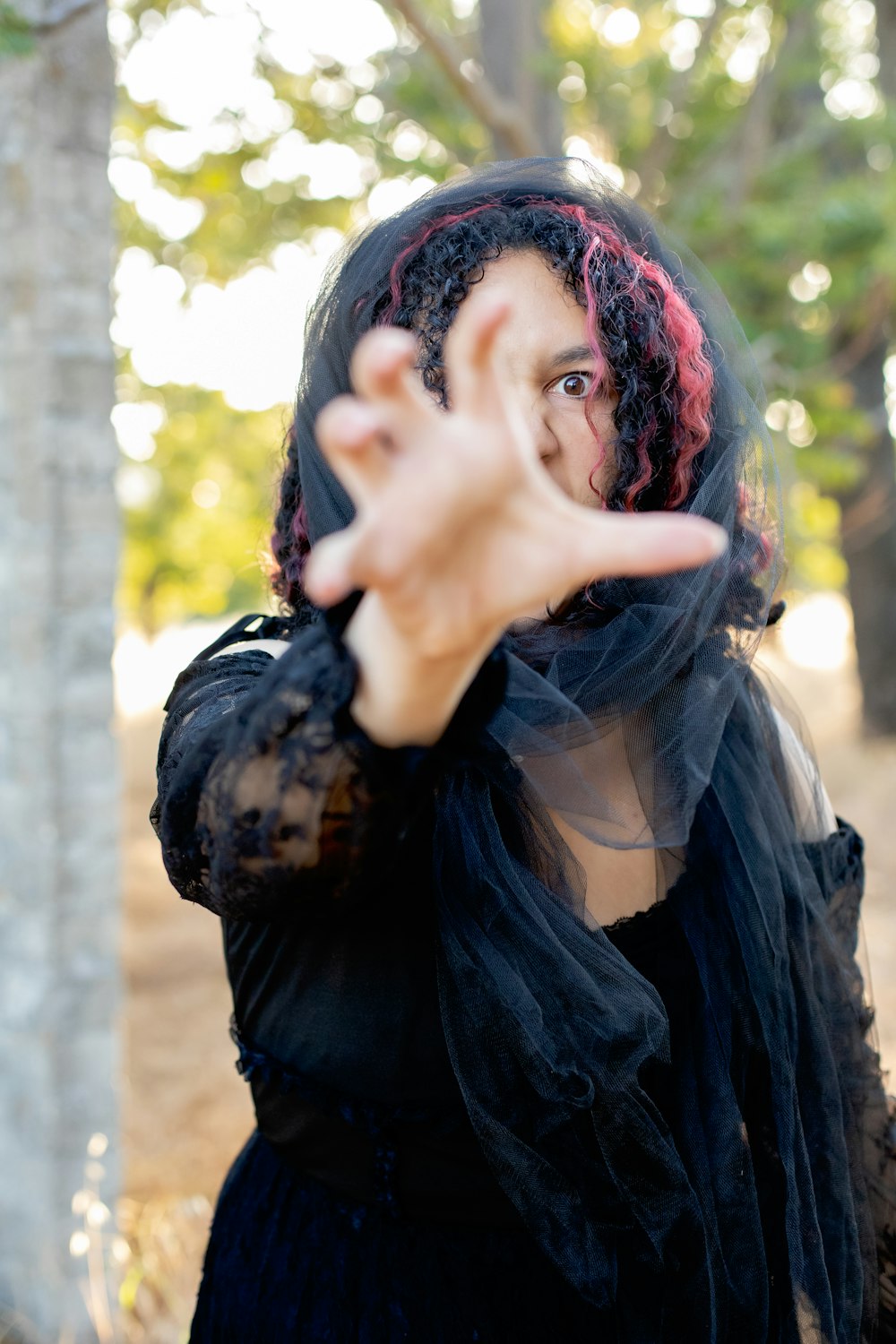 a woman in a black dress making a hand gesture