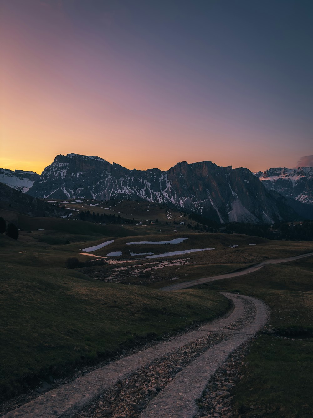 a dirt road in the middle of a grassy field