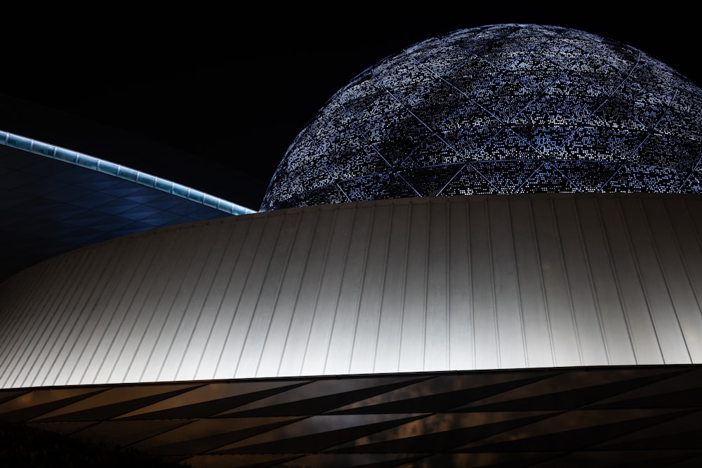 a large dome with a metal roof at night