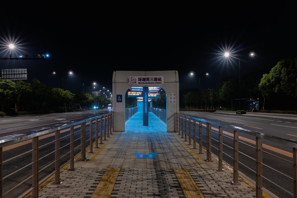 a night scene of a city street with a bridge