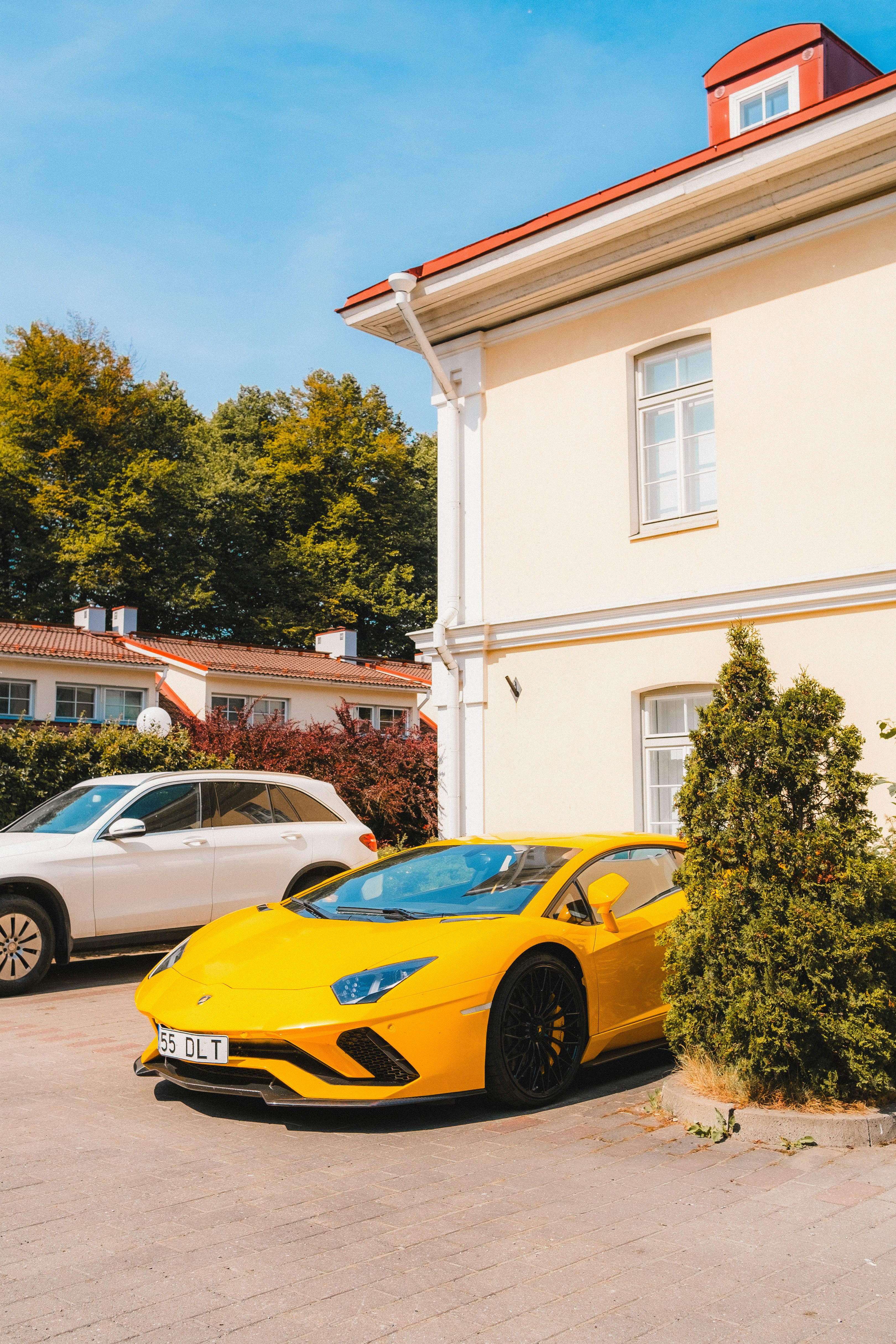 a yellow sports car parked in front of a house
