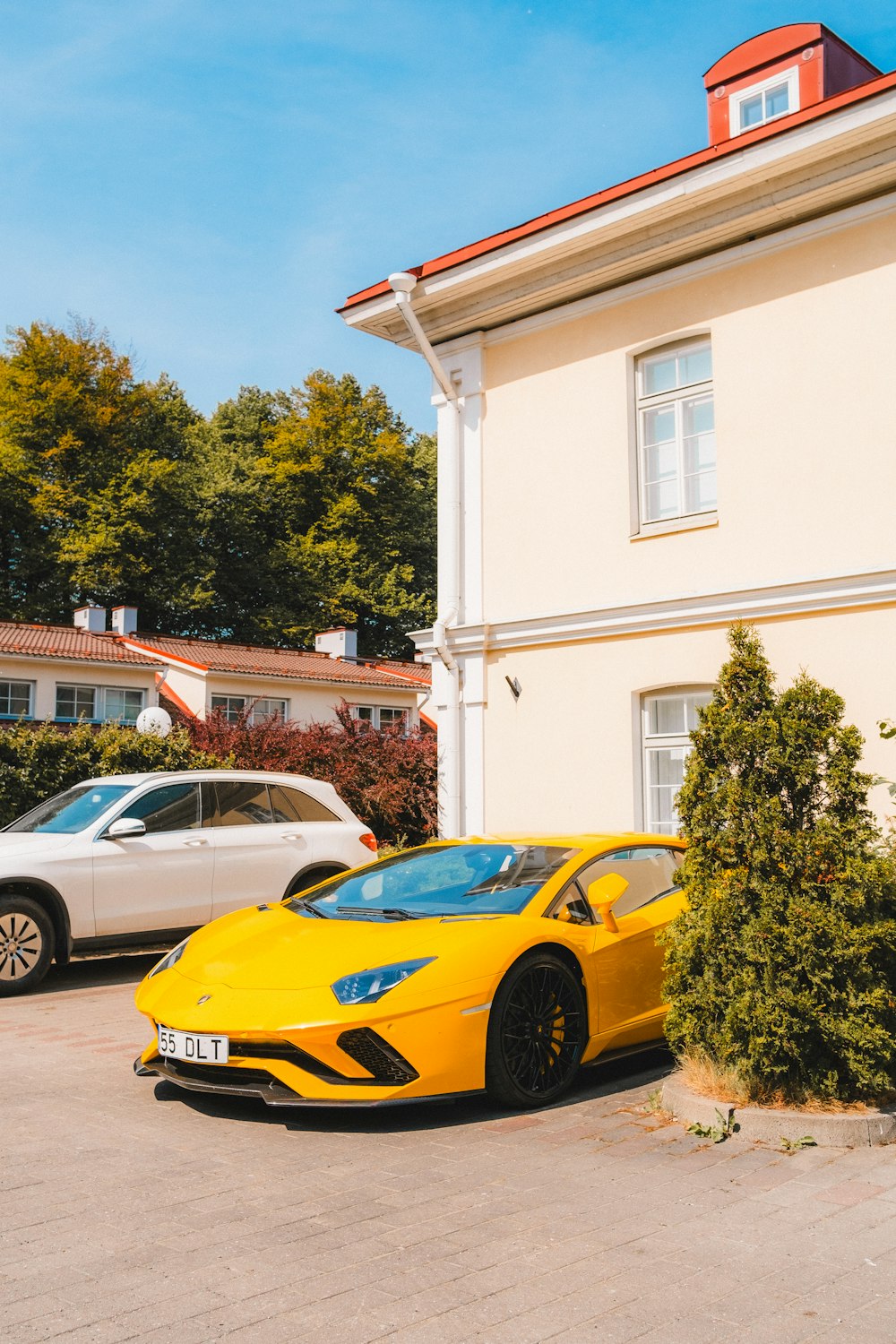 Ein gelber Sportwagen, der vor einem Haus geparkt ist