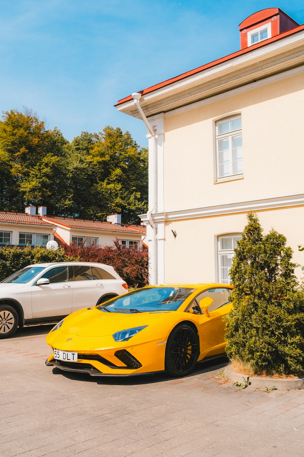a yellow sports car parked in front of a house