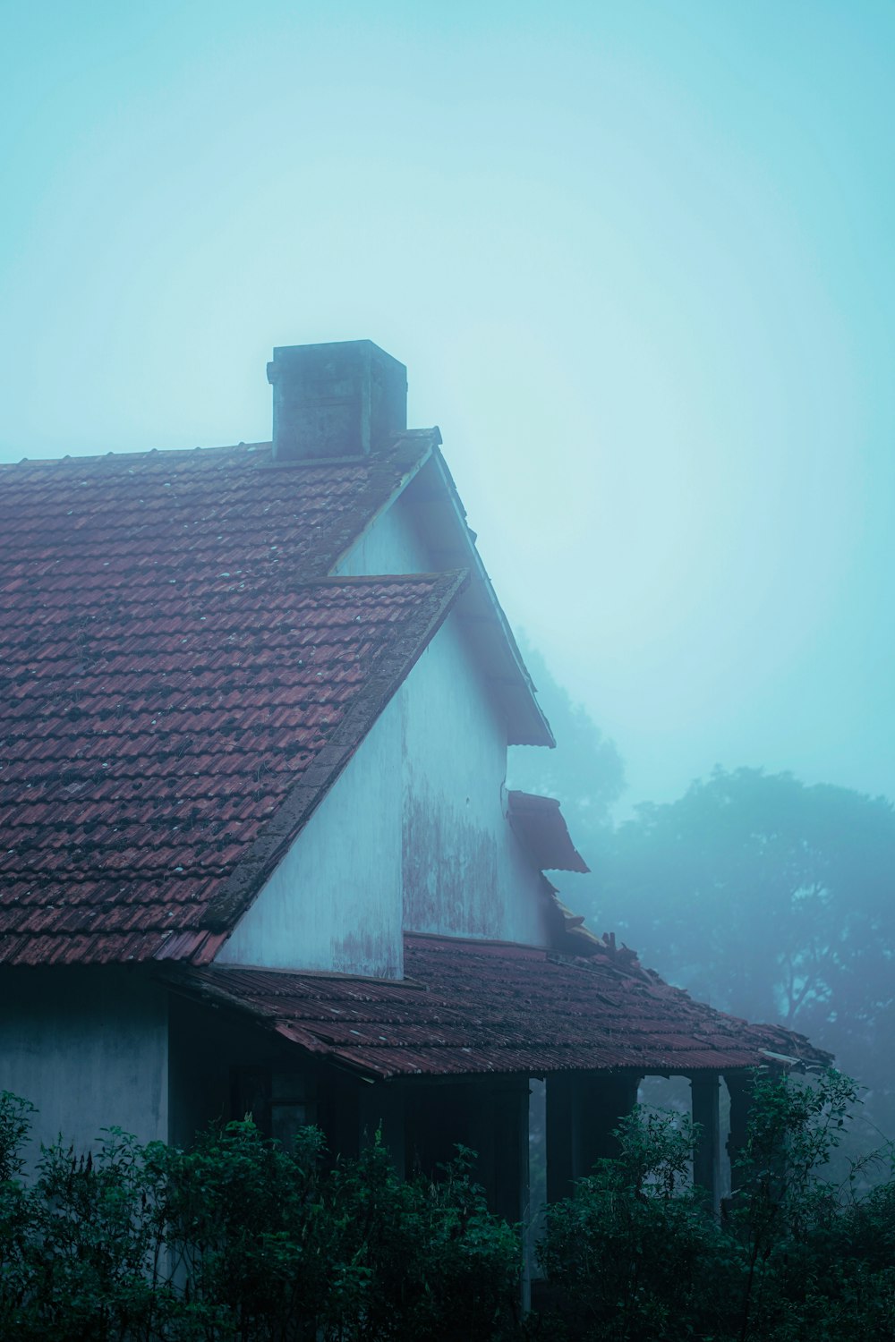a white house with a red roof in the fog
