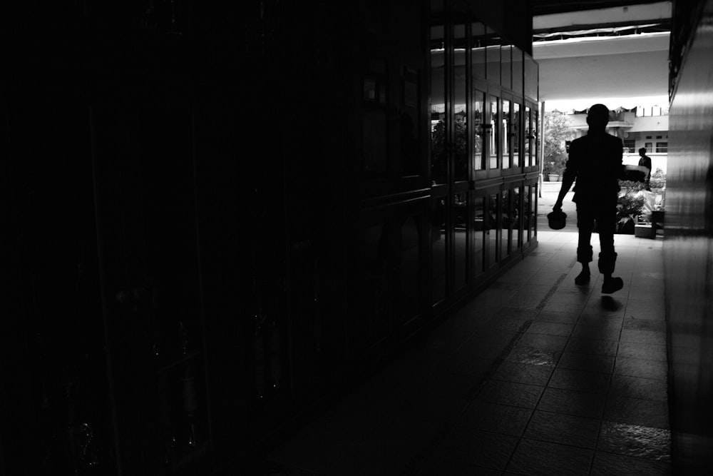 a silhouette of a person walking down a hallway