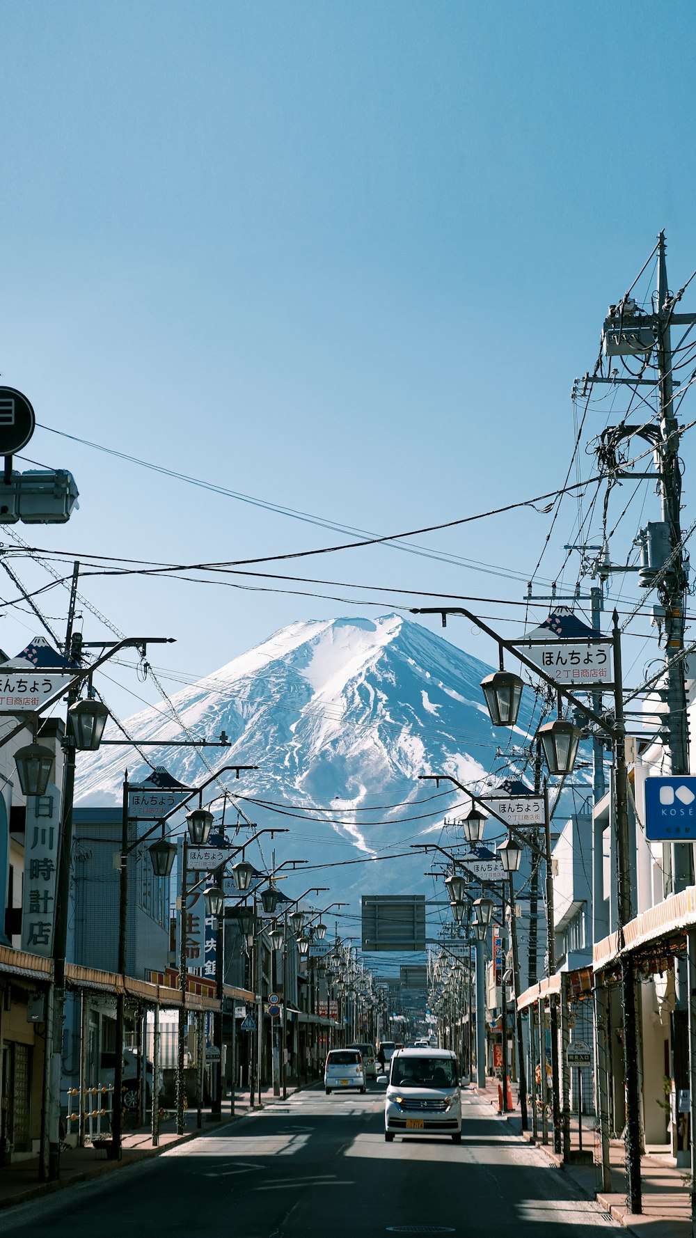 a car driving down a street with a mountain in the background