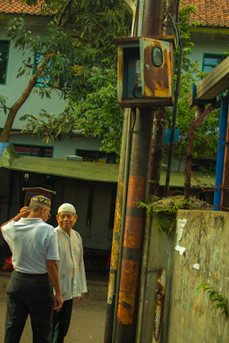 A friendly electrician speaking with a homeowner outside a bright Palm Beach residence.